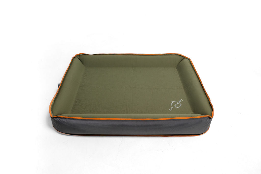 A self inflating travel dog bed with a green, orange, and grey color scheme, featuring rugged design for camping and travel.